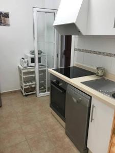 a kitchen with a black counter top and a refrigerator at Casa S Estany in La Savina