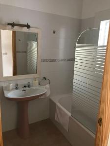 uma casa de banho com um lavatório, um espelho e uma banheira em Casa S Estany em La Savina