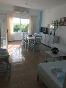 a living room with a table and chairs and a kitchen at Casa S Estany in La Savina