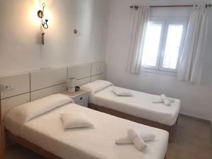 two twin beds in a room with a window at Casa S Estany in La Savina