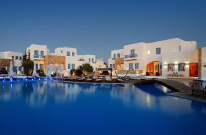 a large swimming pool in front of white buildings at Chora Resort Hotel & Spa in Chora Folegandros