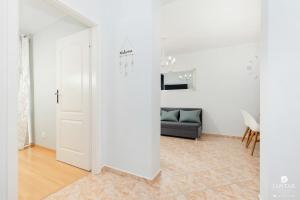 Zimmer mit einer weißen Tür und einem Sofa in der Unterkunft Jantar Apartamenty - Park Side in Kołobrzeg