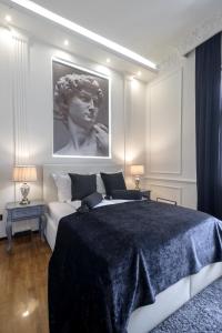 Ben Akiba Luxury Suites في بلغراد: غرفة نوم بسرير كبير وصورة تمثال