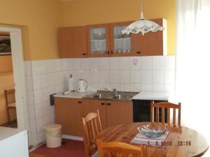 a kitchen with a table and a sink and a table and chairs at Apartman Katarina in Beli Manastir