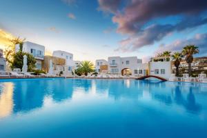 a large swimming pool in a resort with white buildings at Chora Resort Hotel & Spa in Chora Folegandros