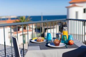 a table with two plates of food on a balcony at YEY Baleal in Peniche