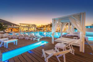 a pool with chaise lounge chairs and a canopy at Chora Resort Hotel & Spa in Chora Folegandros