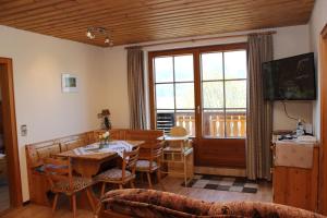 a living room with a table and chairs and a window at Landgasthof zum Schützen in Oberried