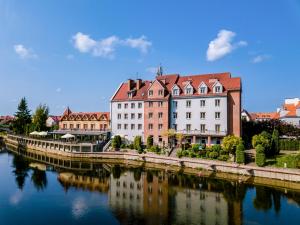 ピシュにあるHotel Nad Pisąの川の横の建物群