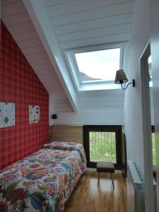 Un dormitorio con una cama y una ventana grande. en Pleta del Mon Atico, en Benasque
