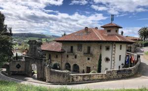 a large stone building with a tile roof at Palacio de Arce in Puente Arce