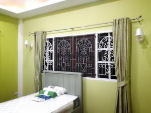 - une chambre avec une fenêtre et un lit avec des serviettes dans l'établissement Single House Sattahip, à Sattahip