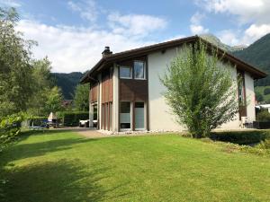 a house with a large lawn in front of it at House Lakeside – GriwaRent AG in Lungern