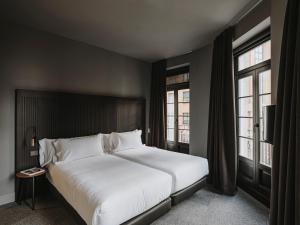 Un pat sau paturi într-o cameră la El Môderne Hotel