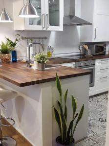 a kitchen with white cabinets and a wooden counter top at Periodista Luca de Tena, lujo y confort en pleno centro in Huelva