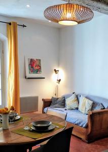 sala de estar con sofá y mesa en Le nid des Arènes, en Arles