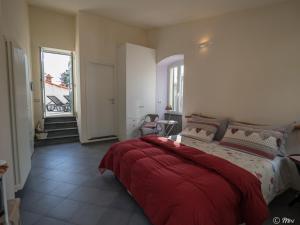 a bedroom with a bed with a red blanket on it at Affittacamere Le Terrazze in Corniglia