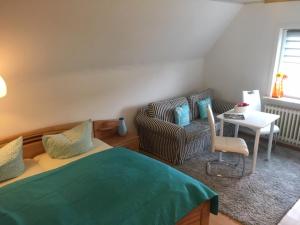 ein Schlafzimmer mit einem Bett, einem Sofa und einem Tisch in der Unterkunft Ferienwohnung Deichgraf in Westerland