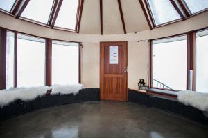 a large room with windows and a wooden door at Klettar Tower Iceland in Fludir