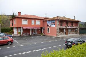 a building on the side of a street with cars parked at Hotel TERRANOVA in Oza dos Ríos