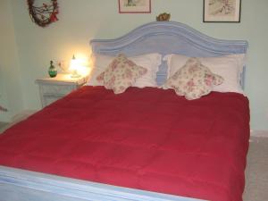 a red bed with pillows and a red blanket at Affittacamere Le Terrazze in Corniglia