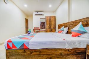- une chambre avec un grand lit en bois et des oreillers colorés dans l'établissement Rutugandh Heritage, à Pune