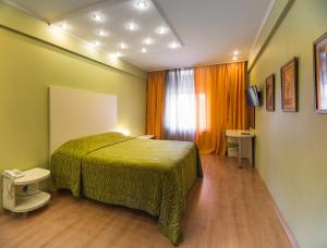 - une chambre avec un lit vert et une fenêtre dans l'établissement Hotel Apartments Adresa, à Chişinău