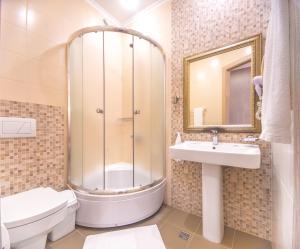 a bathroom with a shower, toilet, sink and tub at Hotel Apartments Adresa in Chişinău