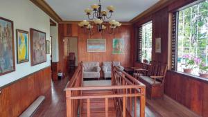 una sala de estar con paredes de madera y una lámpara de araña. en Casa Familya, en Batac