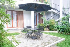 a table and chairs with an umbrella on a patio at Mk House Tendean in Jakarta