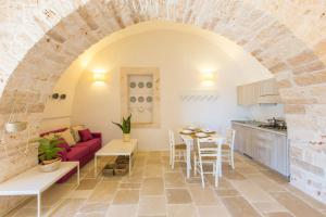 een woonkamer met een rode bank en een tafel bij Masseria Castelluzzo in Ceglie Messapica