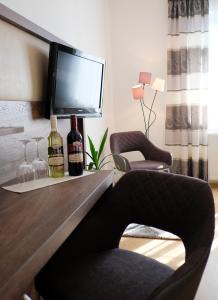 Zimmer mit einem Schreibtisch und 2 Flaschen Wein in der Unterkunft NATIONALPARKHOF GARTNER Weingut-Gästehaus in Illmitz
