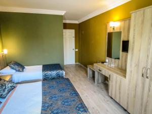 a hotel room with two beds and a desk at Remer Hotel in Fethiye