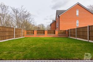 un patio trasero con una valla y una casa en Birmingham Estate III By Prime Stays en Birmingham