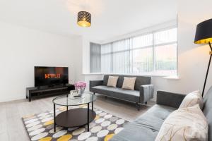 sala de estar con sofá y TV en Birmingham Estate III By Prime Stays en Birmingham