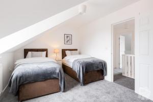 two beds in a bedroom with white walls at Birmingham Estate III By Prime Stays in Birmingham