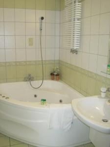 La salle de bains est pourvue d'une baignoire et d'un lavabo. dans l'établissement Titanic, à Białystok