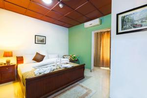 a bedroom with a bed in a room with green walls at Okumah Hotel in Kumasi