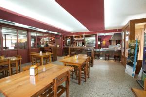 un restaurante con mesas de madera y un bar en HOTEL PARRILLADA TERRANOVA, en Oza dos Ríos