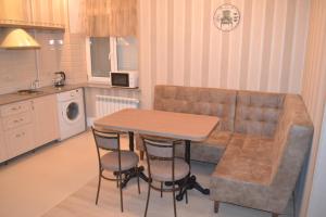 a kitchen with a table, chairs and a refrigerator at Hotel Apartments Adresa in Chişinău