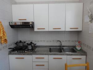 a kitchen with a stove top oven and a sink at Villa Pacis in Naples
