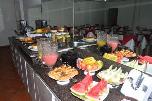 a buffet with fruit and drinks on a table at HOTEL D' LUCCA in Ubá