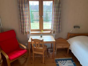 een slaapkamer met een tafel, een stoel en een raam bij Tingvall B&B Eco-Lodge in Bullaren