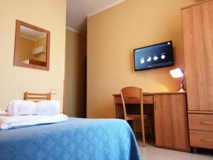 Habitación de hotel con cama, escritorio y TV. en Hotel Il Vulcano, en Tropea