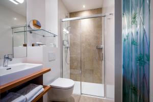 y baño con ducha, aseo y lavamanos. en Strandhotel Alte Donau, en Viena