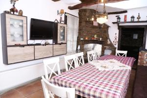 uma sala de jantar com uma mesa e uma lareira em Къща за гости "Жълтицата" em Kostenkovtsi