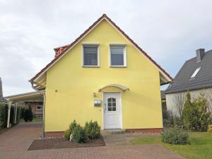 een geel huis met een witte deur bij Ferienhaus Uns lütt Hus mit Sauna in Baabe