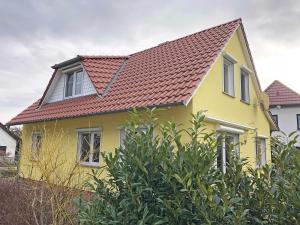 een geel huis met een rood dak bij Ferienhaus Uns lütt Hus mit Sauna in Baabe