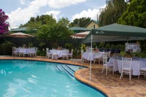 a pool with tables and chairs and a table set up at Classique Grace Boutique Hotel in Johannesburg