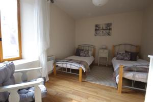 1 dormitorio con 2 camas y ventana en Eymet Townhouse, en Eymet